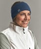 Eine Frau mit blauem Stirnband und weißer Weste lächelt.