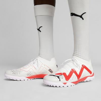 Weiße Fußballschuhe mit roten Details und Puma-Logo. Weiße Fußballschuhe mit roten Details und Puma-Logo.