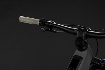 Detailansicht des Lenkers eines Mountain-E-Bikes mit grauem Griff und schwarzem Vorbau. Detailansicht des Lenkers eines Mountain-E-Bikes mit grauem Griff und schwarzem Vorbau.