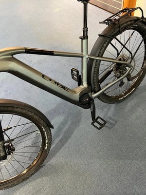 Silbernes Mountainbike mit Schutzblechen und Gepäckträger auf Teppich. Silbernes Mountainbike mit Schutzblechen und Gepäckträger auf Teppich.