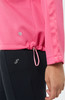 Ein rosafarbenes Oberteil mit verstellbarem Saum und schwarzer Leggings mit Logo.