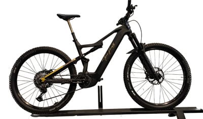Schwarzes E-Bike mit Federung und goldenen Details auf weißem Hintergrund.