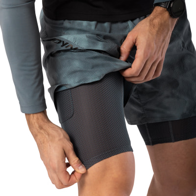 Ein Mann richtet seine Laufshorts mit integrierten Kompressionsshorts. Ein Mann richtet seine Laufshorts mit integrierten Kompressionsshorts.