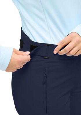 Frau schließt eine dunkelblaue Hose mit Klettverschluss an der Taille. Frau schließt eine dunkelblaue Hose mit Klettverschluss an der Taille.