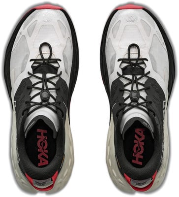 Draufsicht auf ein Paar grau-weiße Laufschuhe mit schwarzen Schnürsenkeln und roten Akzenten. Draufsicht auf ein Paar grau-weiße Laufschuhe mit schwarzen Schnürsenkeln und roten Akzenten.