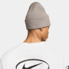 Ein Mann in einer grauen Mütze und einem weißen T-Shirt mit Nike-Logo.