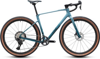 Ein blaugrünes Cube Gravelbike mit braunen Reifen und schwarzen Komponenten.