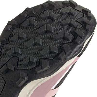 Nahaufnahme der Sohle eines rosafarbenen Laufschuhs mit ausgeprägtem Profil für besseren Halt. Nahaufnahme der Sohle eines rosafarbenen Laufschuhs mit ausgeprägtem Profil für besseren Halt.