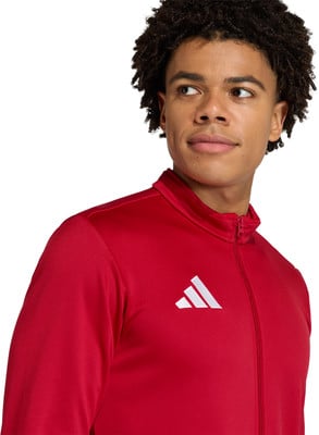 Junger Mann in roter Adidas-Sportjacke vor weißem Hintergrund. Junger Mann in roter Adidas-Sportjacke vor weißem Hintergrund.