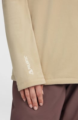 Auf dem Ärmel eines beigen Fleece-Kleidungsstücks steht die weiße Aufschrift POLARTEC. Auf dem Ärmel eines beigen Fleece-Kleidungsstücks steht die weiße Aufschrift POLARTEC.