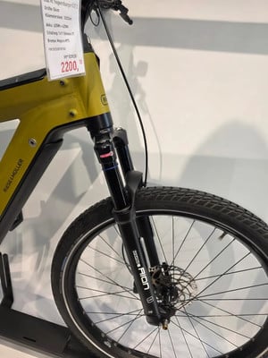 Gelbes Riese & Müller Supercharger GT2 E-Bike mit Preisschild 2200 Gelbes Riese & Müller Supercharger GT2 E-Bike mit Preisschild 2200
