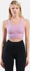 Frau in einem lavendelfarbenen Sportoberteil und schwarzer Leggings.