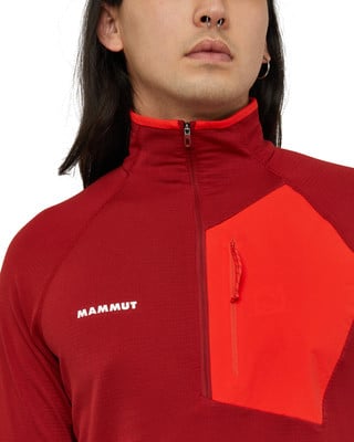 Detail eines roten Herren-Fleece-Oberteils mit Mammut-Logo und Tasche. Detail eines roten Herren-Fleece-Oberteils mit Mammut-Logo und Tasche.