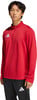 Junger Mann in einem roten Adidas-Pullover und schwarzer Hose.
