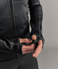Detail einer Hand, die durch eine Daumenöffnung am Ärmel einer Jacke greift.