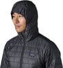 Ein Mann in einer dunklen Steppjacke mit Kapuze und Patagonia-Logo auf der Brust.