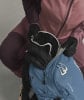 Eine Person packt Skibrille und Handschuhe in einen Rucksack.