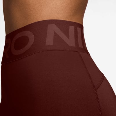 Detail einer dunkelroten Damenleggings mit Nike Pro Logo auf dem Bund. Detail einer dunkelroten Damenleggings mit Nike Pro Logo auf dem Bund.