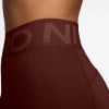 Detail einer dunkelroten Damenleggings mit Nike Pro Logo auf dem Bund.