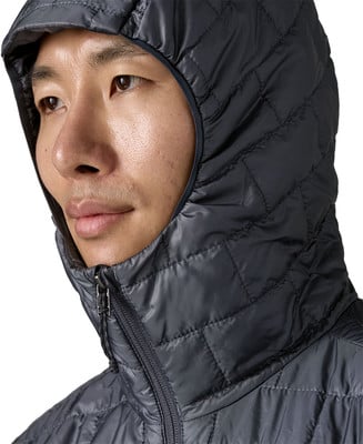 Mann in dunkler gesteppter Kapuzenjacke, Nahaufnahme des Gesichts.