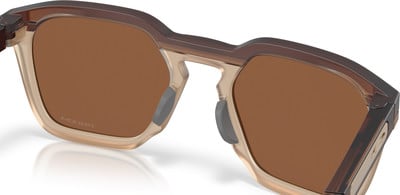 Nahaufnahme einer braunen Sonnenbrille mit transparentem Rahmen und dunklen Bügeln. Nahaufnahme einer braunen Sonnenbrille mit transparentem Rahmen und dunklen Bügeln.
