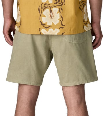 Ein Mann trägt beige Cordshorts und ein gelbes Hemd mit Blumenmuster. Ein Mann trägt beige Cordshorts und ein gelbes Hemd mit Blumenmuster.