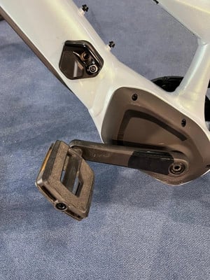 Detail eines E-Bike-Rahmens mit Pedal und Kurbel auf blauem Grund. Detail eines E-Bike-Rahmens mit Pedal und Kurbel auf blauem Grund.