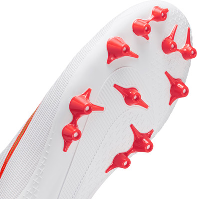 Nahaufnahme einer weißen Fußballschuhsohle mit roten Stollen. Nahaufnahme einer weißen Fußballschuhsohle mit roten Stollen.