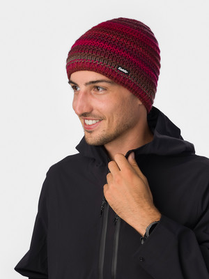 Ein Mann mit einer roten Strickmütze und schwarzer Jacke richtet seinen Kragen. Ein Mann mit einer roten Strickmütze und schwarzer Jacke richtet seinen Kragen.
