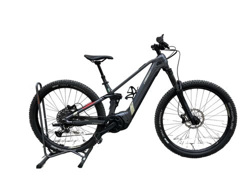 Graues E-Mountainbike auf Ständer mit Federung und Scheibenbremsen.