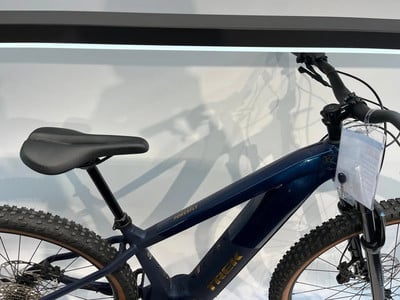 Ein blaues Trek E-Mountainbike mit schwarzem Sattel und Rahmendetails.