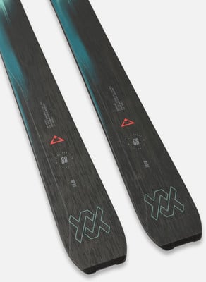 Zwei Skier mit modernem Design und blauen Akzenten auf dunkler Oberfläche. Zwei Skier mit modernem Design und blauen Akzenten auf dunkler Oberfläche.