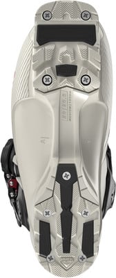 Ansicht von unten auf einen weißen Skischuh mit schwarzen Elementen und Schrauben. Ansicht von unten auf einen weißen Skischuh mit schwarzen Elementen und Schrauben.
