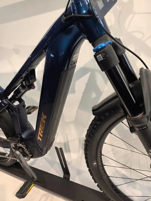 Ein dunkelblaues Trek E-Bike mit Dämpfer und Vorderradfederung.