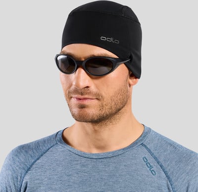 Ein Mann mit schwarzer Mütze und Sonnenbrille auf grauem Hintergrund. Ein Mann mit schwarzer Mütze und Sonnenbrille auf grauem Hintergrund.