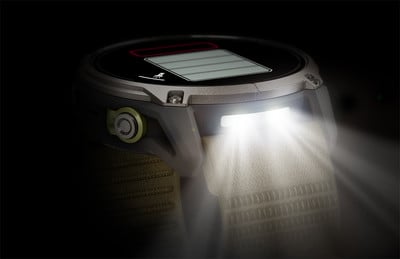 Eine Smartwatch mit integrierter Taschenlampe beleuchtet ein Stoffarmband.