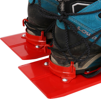 Rote Schneeschuhe mit blauen Stiefeln, die mit einer Schnur befestigt sind.