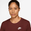 Eine Frau in einem dunkelroten Nike-T-Shirt mit Logo auf der Brust.