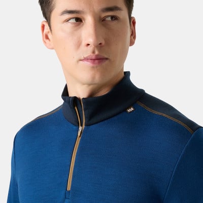 Mann in blauem Shirt mit kurzem Reißverschluss und HH-Logo. Mann in blauem Shirt mit kurzem Reißverschluss und HH-Logo.