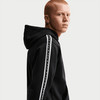 Mann in einem schwarzen Hoodie mit Nike-Logo auf dem Ärmel.