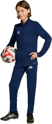 Junge im dunkelblauen Adidas-Anzug hält einen Fußball.