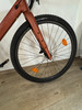 Vorderrad eines Fahrrads mit orangefarbenem Reflektor und Scheibenbremse.