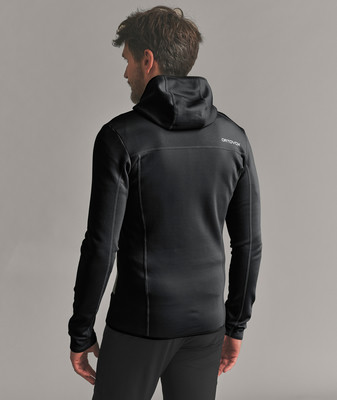 Ein Mann in einem schwarzen Kapuzenpullover von Ortovox blickt über die Schulter. Ein Mann in einem schwarzen Kapuzenpullover von Ortovox blickt über die Schulter.