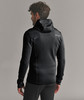 Ein Mann in einem schwarzen Kapuzenpullover von Ortovox blickt über die Schulter.