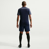 Rückansicht eines Mannes in Fußballtrikot, Shorts und schwarzen Socken.