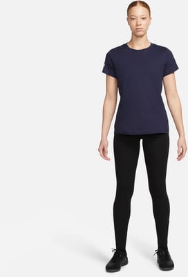 Eine Frau in einem dunkelblauen T-Shirt und schwarzen Leggings steht vor weißem Hintergrund. Eine Frau in einem dunkelblauen T-Shirt und schwarzen Leggings steht vor weißem Hintergrund.