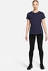 Eine Frau in einem dunkelblauen T-Shirt und schwarzen Leggings steht vor weißem Hintergrund.