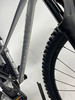 Silbernes Mountainbike mit großem Vorderrad und Federgabel.