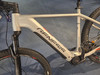 Silbernes Genesis E-Bike mit schwarzen Details und Logo auf dem Rahmen.