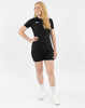 Eine Frau in einem schwarzen T-Shirt und Shorts mit weißen Turnschuhen und Socken.